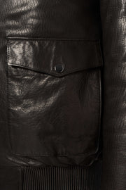 Black shearling leather bomber jacket with curly lamb collar and military-inspired design