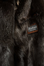 Men's brown leather bomber jacket with black mink fur collar on a mannequin